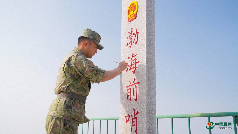 11.守岛官兵为界碑描红，坚定守防信念。张国强摄