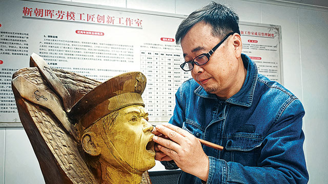 退役军人靳朝晖用根雕技艺创作国防题材作品