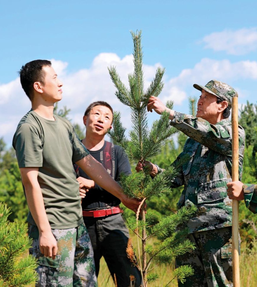 2021-08-26，张连印带着贫困户魏随舍和教育基地工作人员种树。（丁美宁 摄）